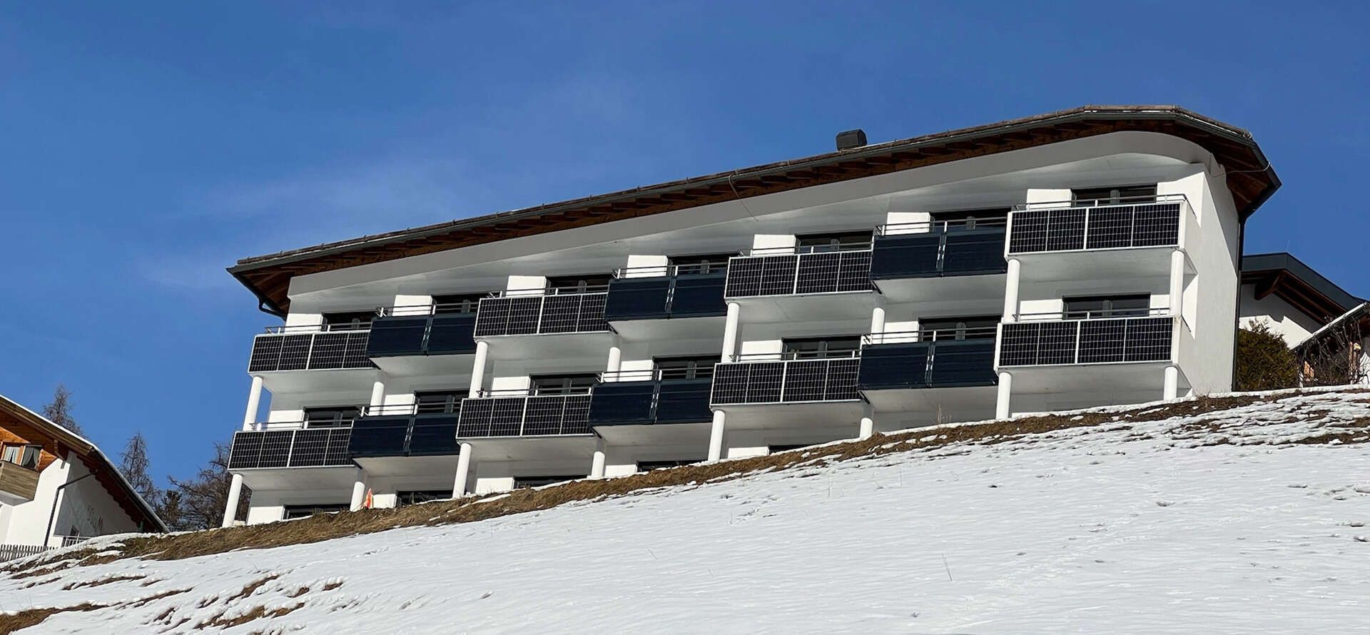 Hotel Bärolina: View of the balconies in winter with photovoltaic systems