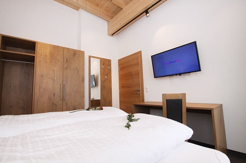 Doppelbettzimmer mit TV, Kleiderschrank und Schreibtisch