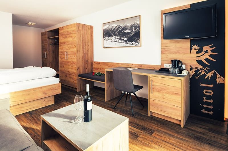 Double room with bed and sofa at Hotel Bärolina Serfaus