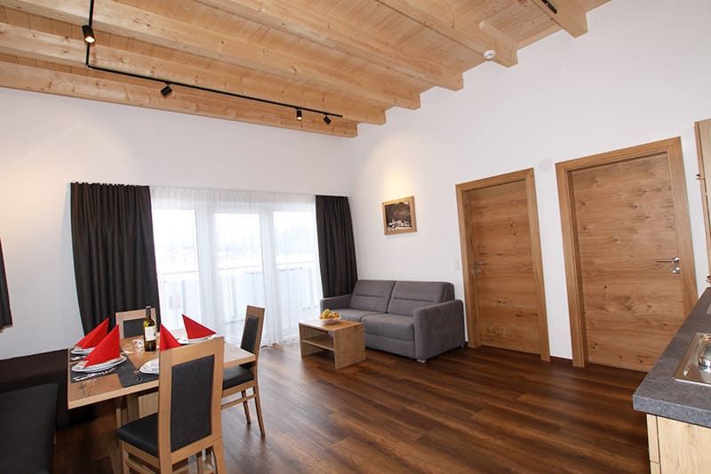 Esstisch mit Stühle und Sitzbank und Couch mit Tisch und Balkontür